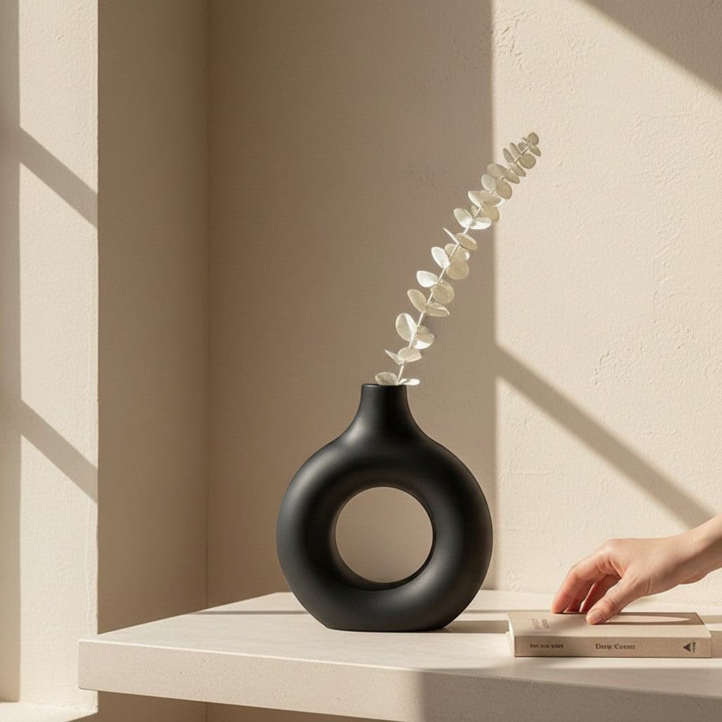 Galiana Vase sculptural noir en céramique mate avec une branche de feuillage séché. Design moderne.