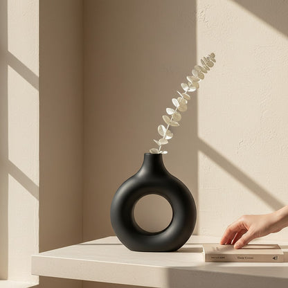 Galiana Vase sculptural noir en céramique mate avec une branche de feuillage séché. Design moderne.